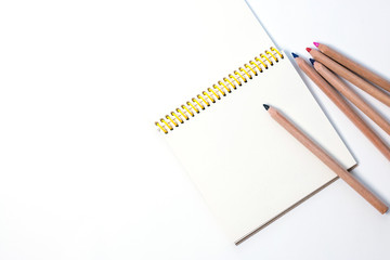 education or draw, sketch concept: several pencils and composition clean notepad against the backdrop of the new academic year. Copy space, and empty notebook, selective focus