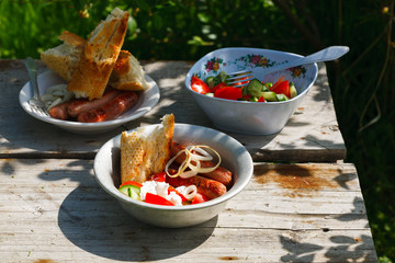 BBQ. Village lunch. grilled sausages with vegetable salad, onion and grilled bread.