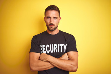 Young safeguard man wearing security uniform over yellow isolated background skeptic and nervous,...