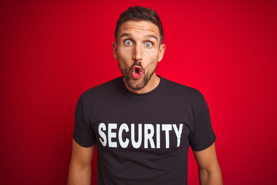 Young safeguard man wearing security uniform over red isolated background afraid and shocked with surprise expression, fear and excited face.