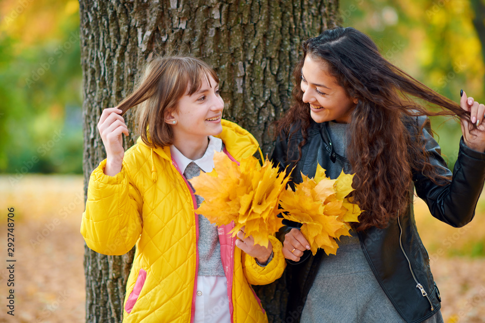 Wall mural woman posing with autumn leaves in city park, outdoor portrait