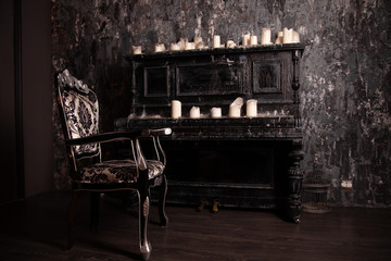 old black vintage piano with white candles and retro chair. nobody
