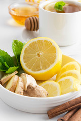 Lemon and ginger slices with mint white background copy space. Autumn, winter tea ingredient