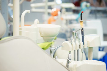 Dental equipment at the clinic close-up. Medical instruments for examining and treating patients. Dentistry and dental treatment. Dental chair, details. Tubes, lamps, accessories, tool table close-up.