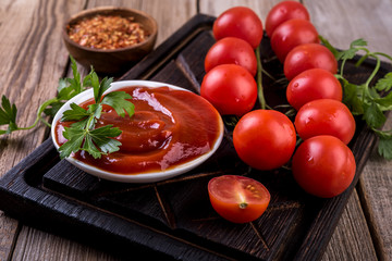 tomato sauce and fresh tomatoes on wooden table