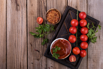 tomato sauce and fresh tomatoes on wooden table, top view
