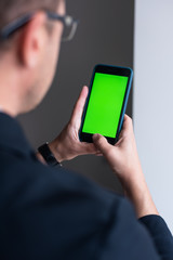 Businessman  showing smartphone with green screen, app.
