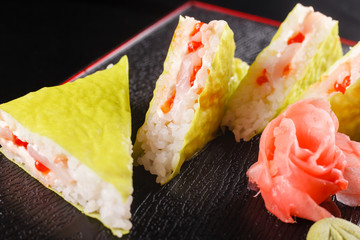 Triangular pieces. Japanese food, tasty of meal for lunch. Seafood. Sushi with eel, salmon, trout, tuna black background.