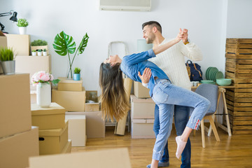 Beautiful young couple moving to a new home, dancing in love celebrating new apartment
