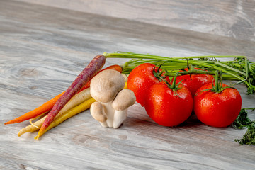 Close up of carrots and tomatoes with a bunch of mushrooms