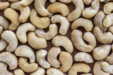 Background in the form of cashew nuts on a brown wooden surface