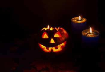 Halloween pumpkin on dark background with candles