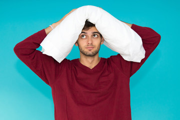 young man with pillow isolated on color background