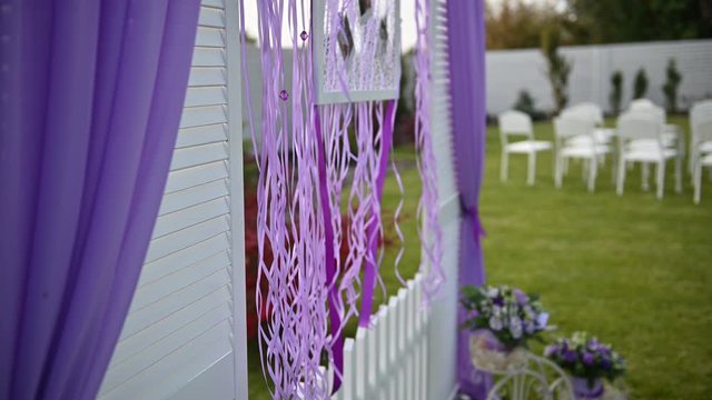Wedding ceremony decoration on wind. Wind blows colorful ribbons in spring sunlight