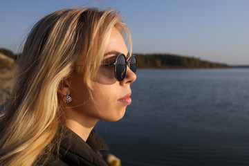 Girl in autumn clothes posing on the lake