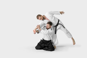 Two caucasian men are practicing aikido on the tatami (isolation path included) - obrazy, fototapety, plakaty