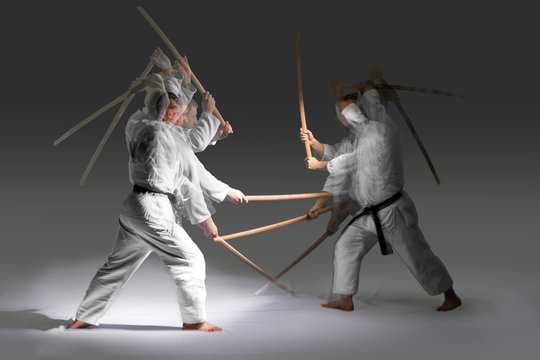 Two caucasian men are practicing aikido with the bokken