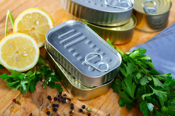 Tin cans with ring pull on wooden surface with lemon and greens