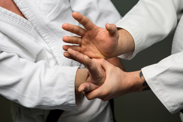 Two caucasian men are practicing aikido on the tatami - obrazy, fototapety, plakaty