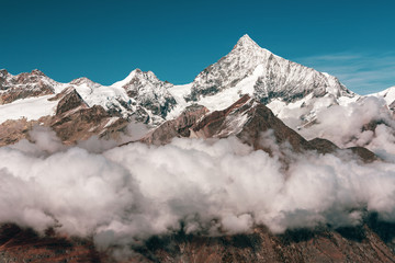 Fototapeta na wymiar Panorama view of Alps above the clouds