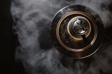  top view of a hookah on a black background, and around smoke