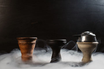  clay bowl for tobacco on a black background with smoke around