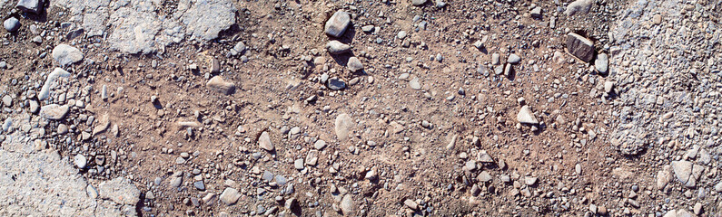 Destroyed asphalt cover on road. Bad road condition that needs repair. Banner size, top view