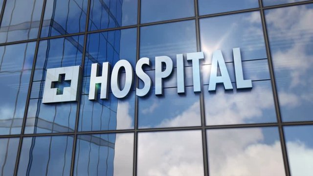Hospital glass building. Mirrored sky and city on modern facade. Health, clinic, emergency, healthcare and medical concept in 3D rendering animation.
