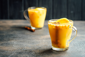 sea buckthorn tea with orange and spices on a dark background