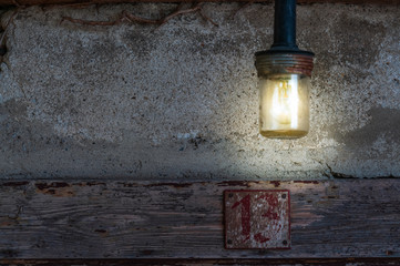 Betontextur mit Holzbalken, Hausnumer 13 und alter Lampe