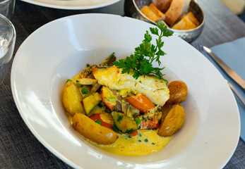 Hake fillet with vegetables and potatoes. French dish