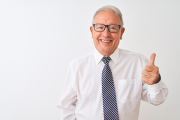 Senior grey-haired businessman wearing tie and glasses over isolated white background doing happy thumbs up gesture with hand. Approving expression looking at the camera with showing success.