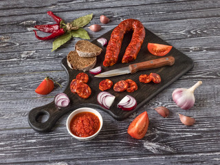 Chorizo sausage slices on a dark wooden background. 