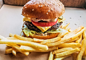 Hamburger and fried potatoes wooden table background