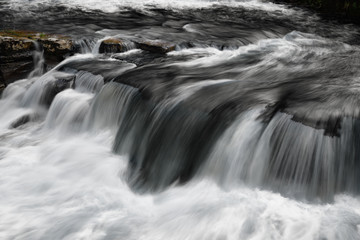 Fototapeta na wymiar Long exposure with blurred water of detail of Richmond Falls on the River Swale at Richmond North Yorkshire England