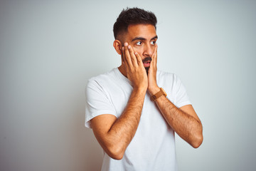 Young indian man wearing t-shirt standing over isolated white background Tired hands covering face, depression and sadness, upset and irritated for problem