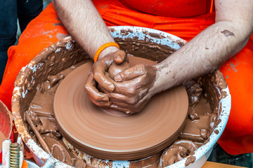 potter making small water container from soil