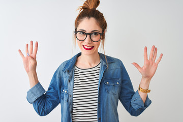 Redhead woman wearing striped t-shirt denim shirt and glasses over isolated white background...