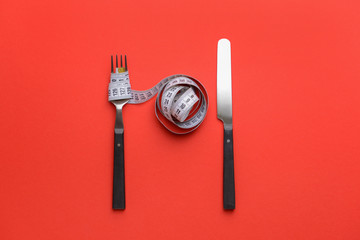 Cutlery with measuring tape on color background. Concept of diet