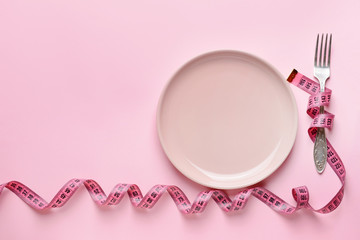 Fork with plate and measuring tape on color background. Concept of diet