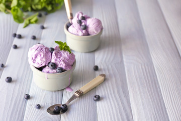 Bowls with tasty blueberry ice cream on wooden table