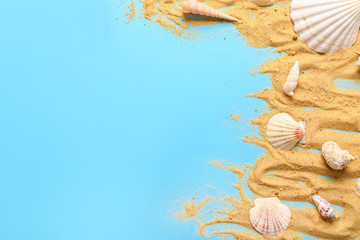 Beach sand and seashells on color background