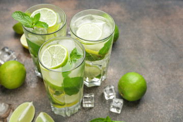 Glasses of fresh mojito on grey background