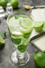 Glass of fresh mojito on grey table