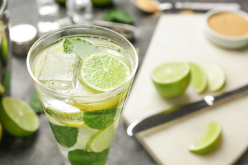 Glass of fresh mojito on grey table, closeup
