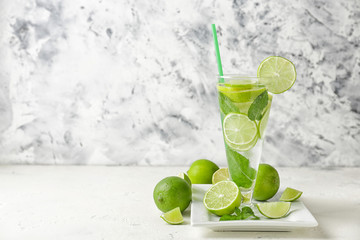 Glass of fresh mojito on white table