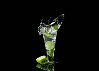 Glass of fresh mojito with splashes on dark background