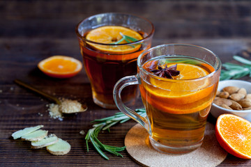 Two cups of hot tea with oranges, closeup