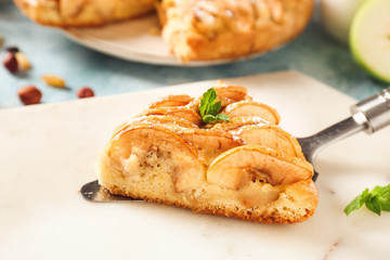 Slice of sweet apple pie on table
