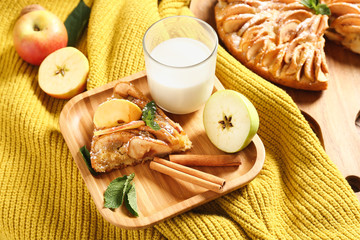 Plate with piece of sweet apple pie and glass of milk on table